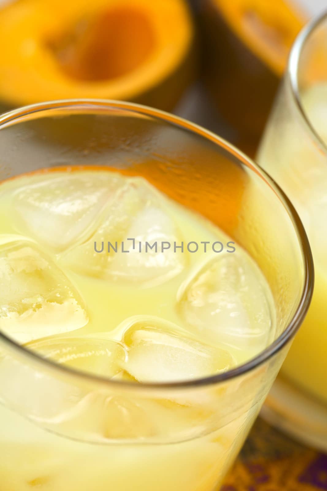Peruvian cream liqueur made of lucuma fruit served in glass with ice cubes (Selective Focus, Focus one third into the drink)