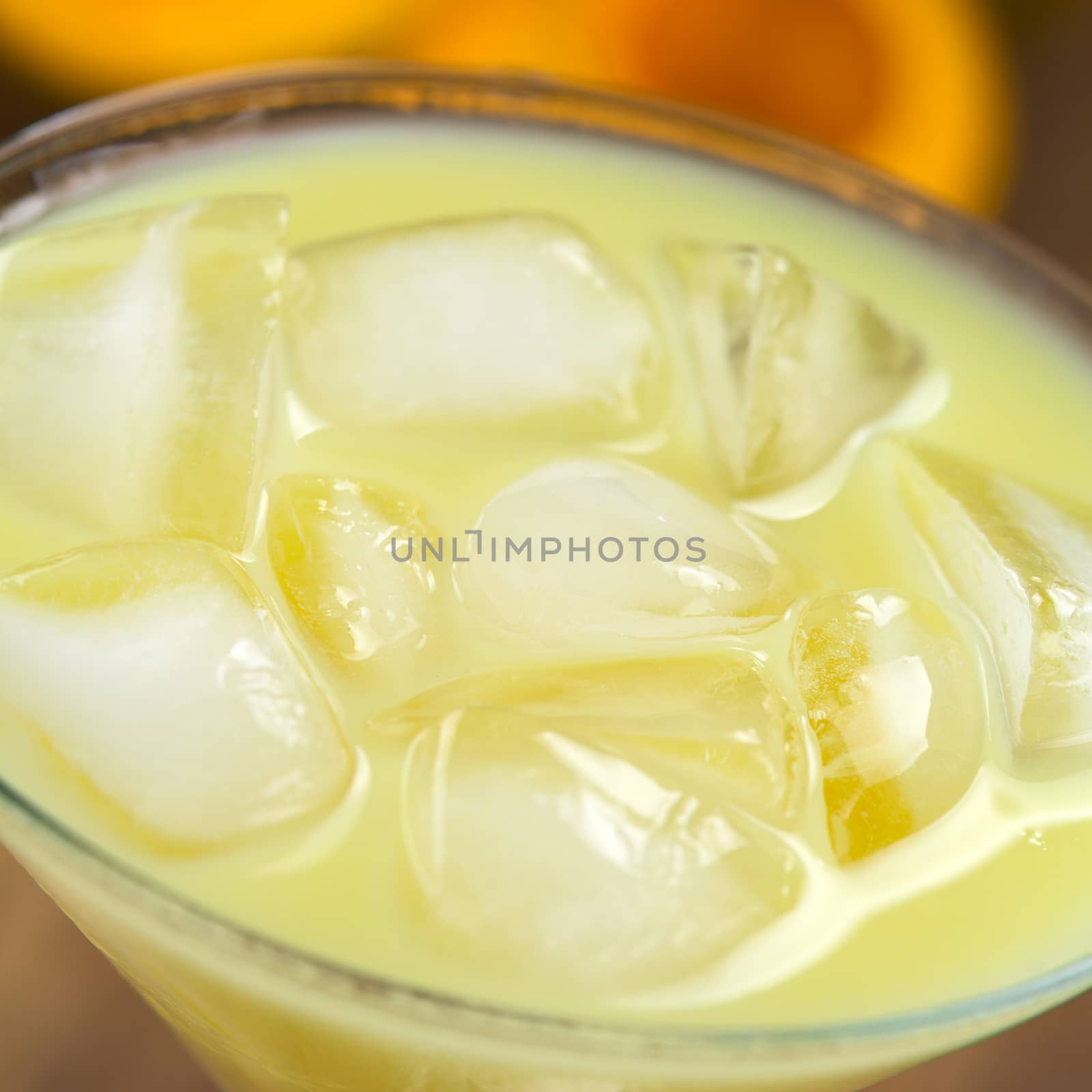 Peruvian cream liqueur made of lucuma fruit served in cocktail glass with ice cubes (Selective Focus, Focus one third into the ice cubes)