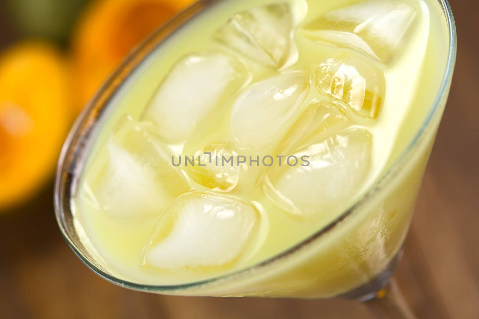 Peruvian cream liqueur made of lucuma fruit served in cocktail glass with ice cubes (Selective Focus, Focus one third into the ice cubes)