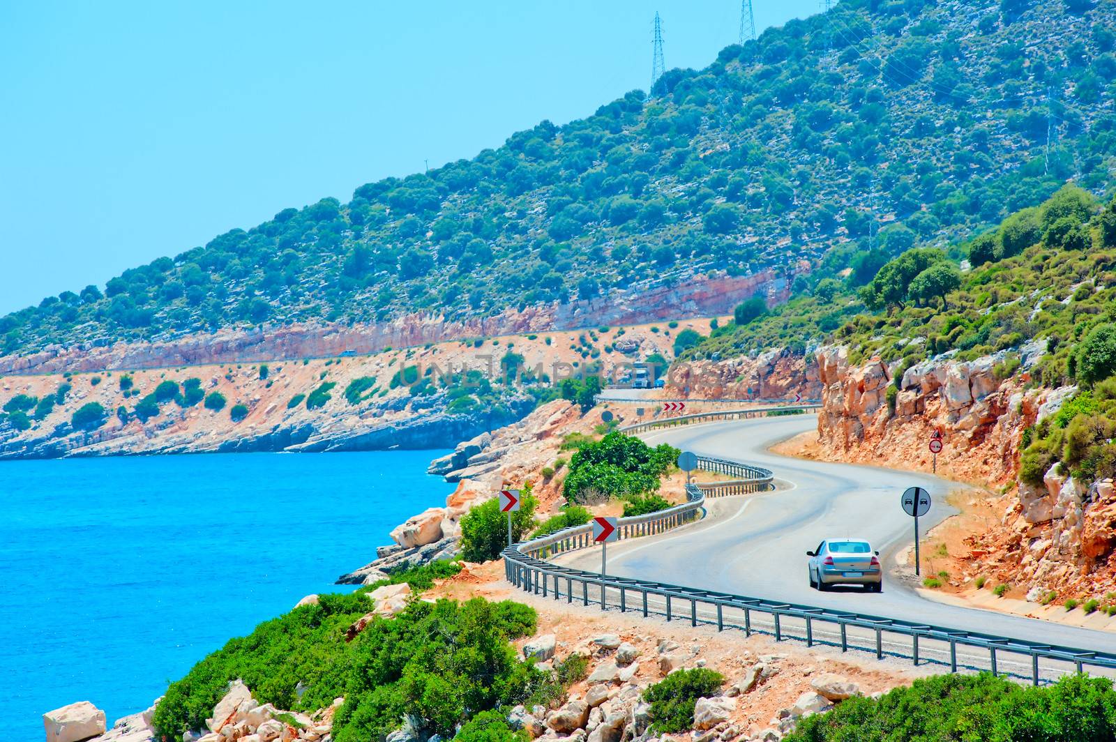 car driving on mountain road along the sea