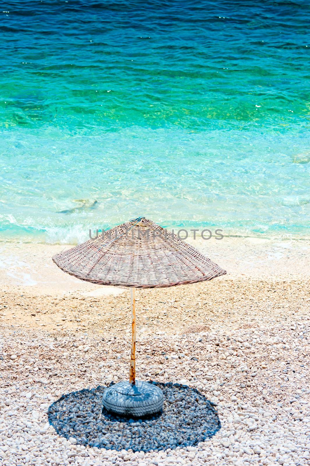 lonely beach umbrella casts a shadow