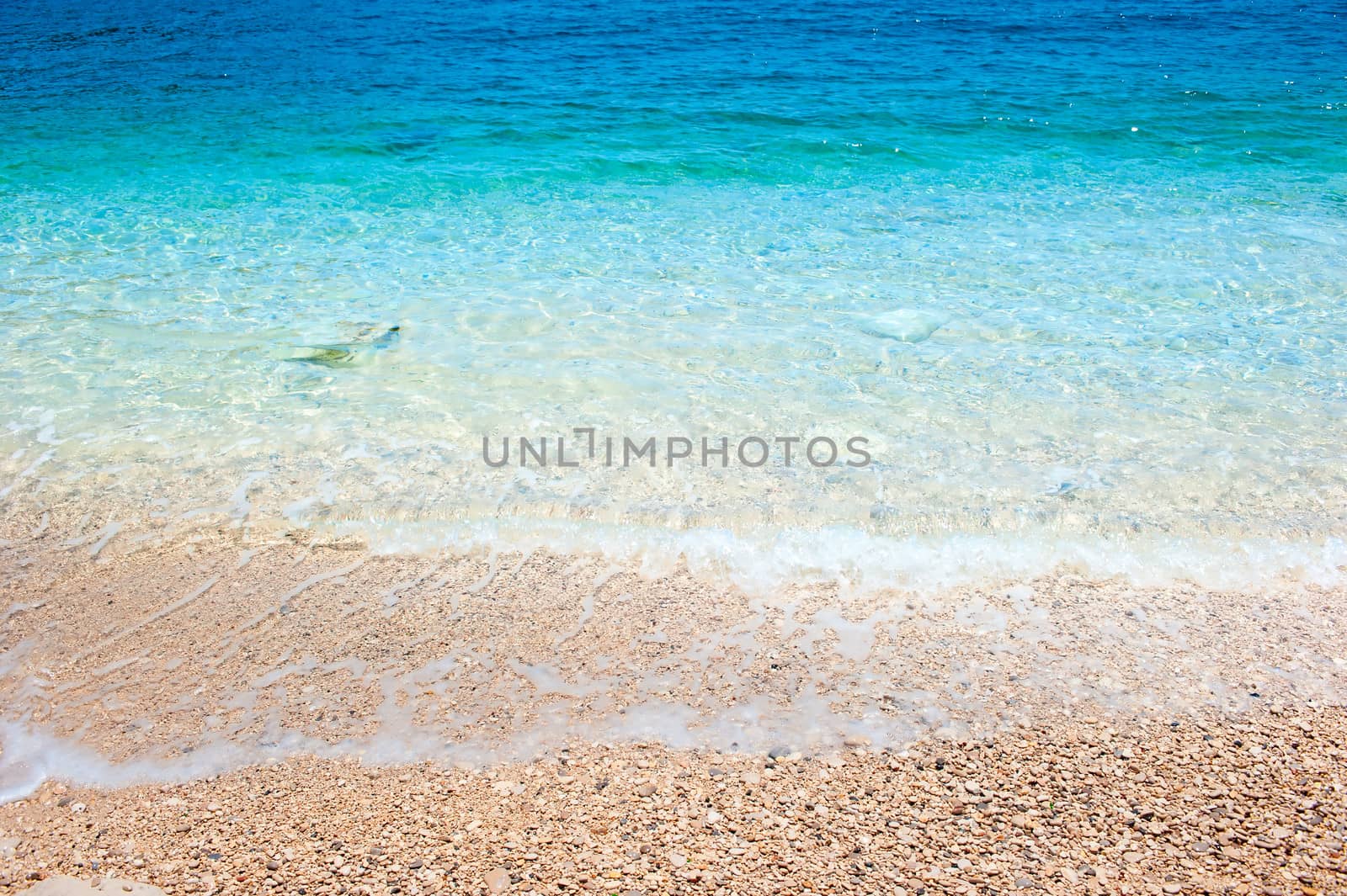 clean sea water rolls on the rocky shore