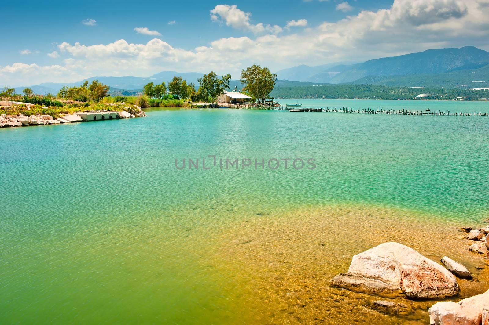 The picturesque azure lake with a fishing lodge on the shore