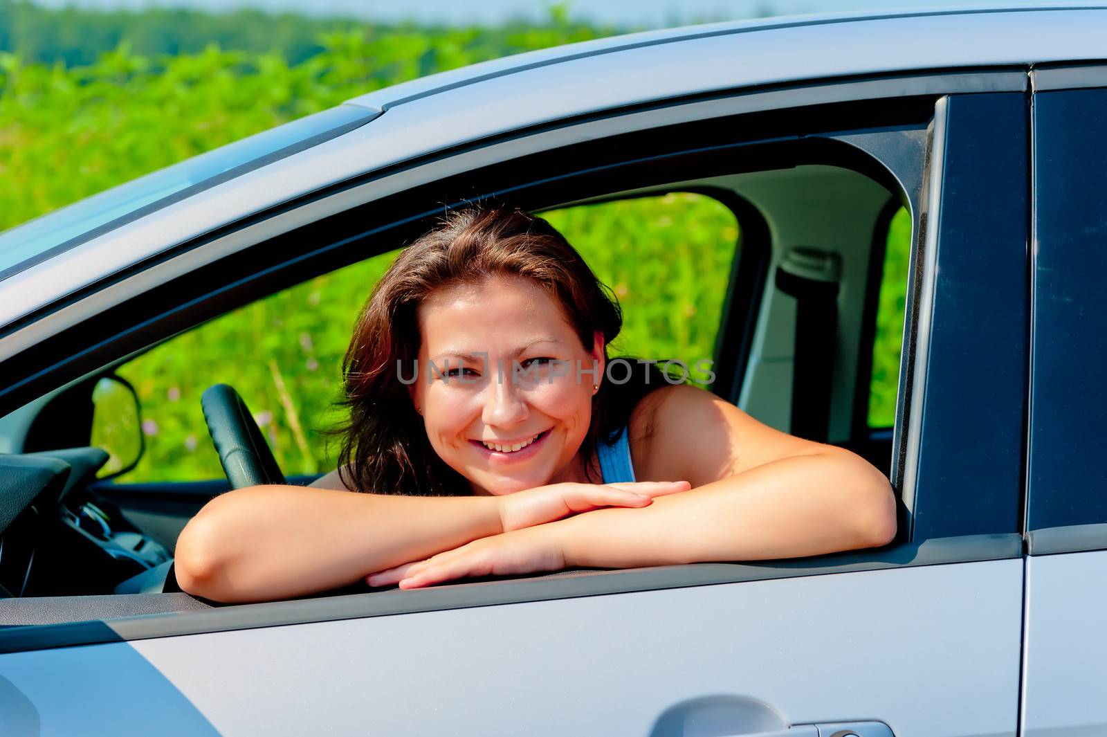 Happy female driver in her new car by kosmsos111