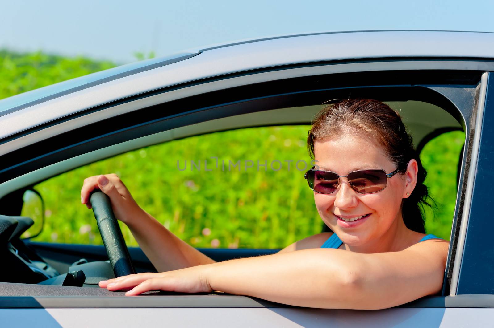 woman in sunglasses driving a modern car by kosmsos111