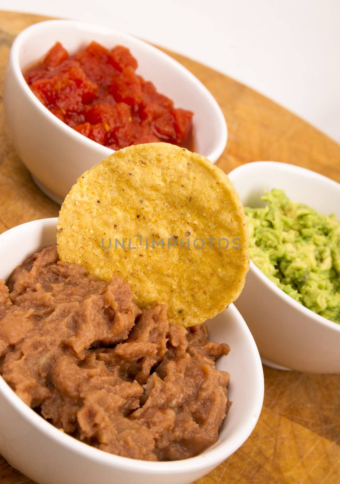 Food Appetizers Chips and Salsa Refried Beans Guacamole on Wood Cutting Board 