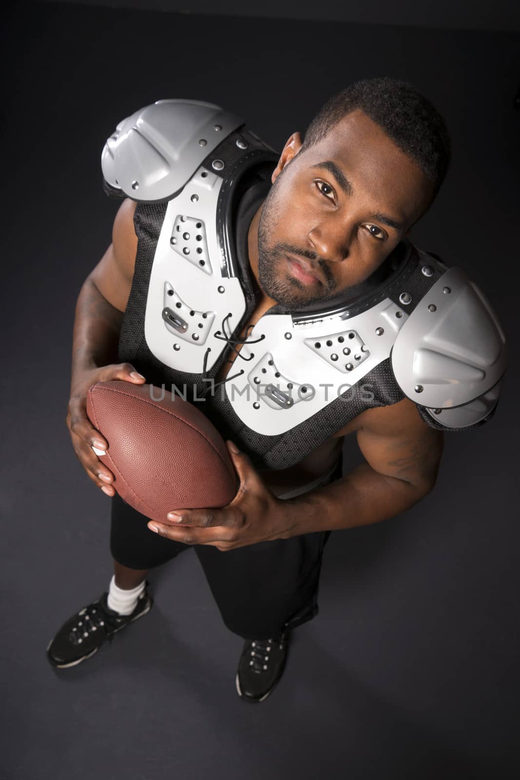 African American Man Football Player Shoulder Pads Looking Up by ChrisBoswell