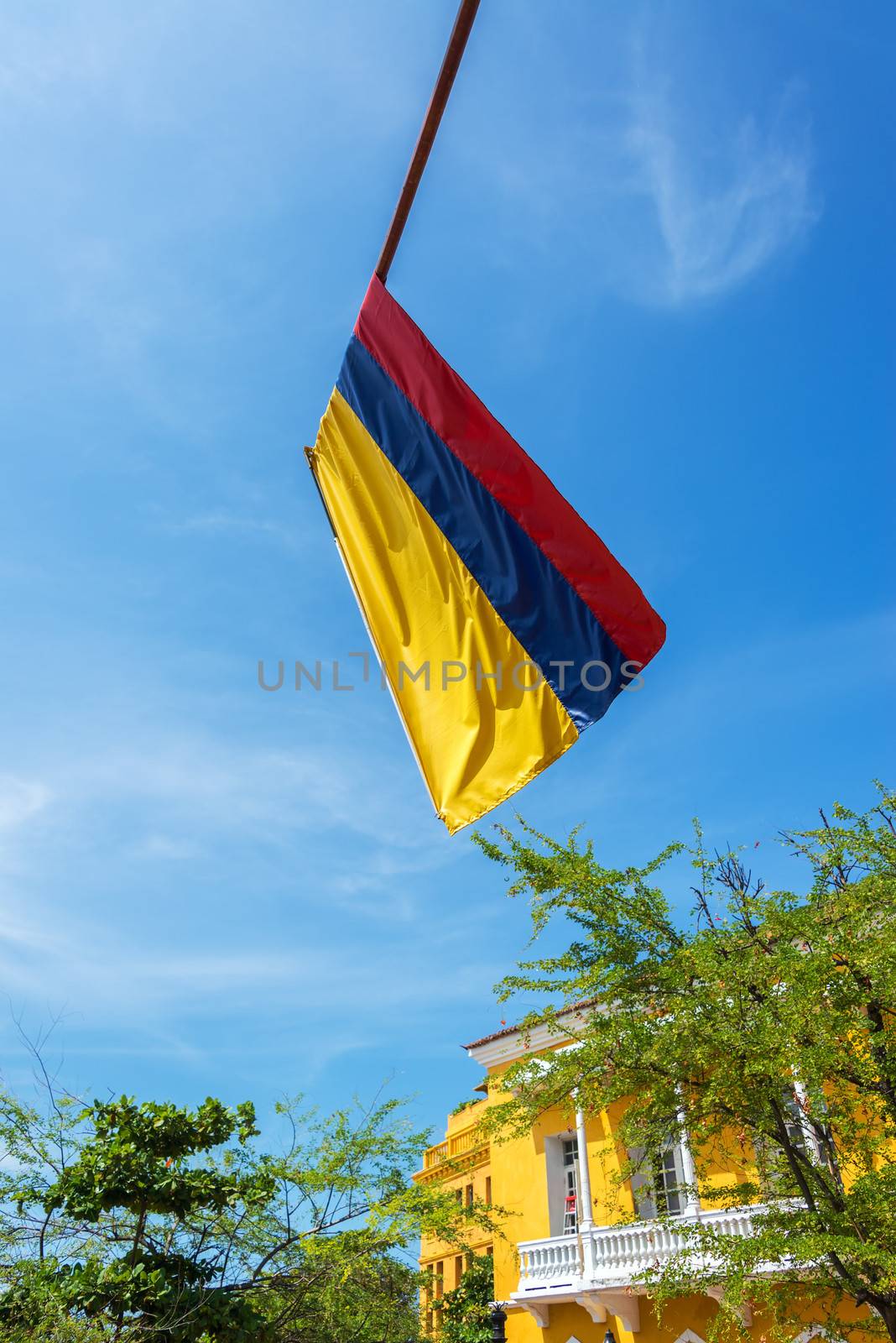 Colombian flag in the old town of Cartagena, Colombia with blue sky and colonial architecture