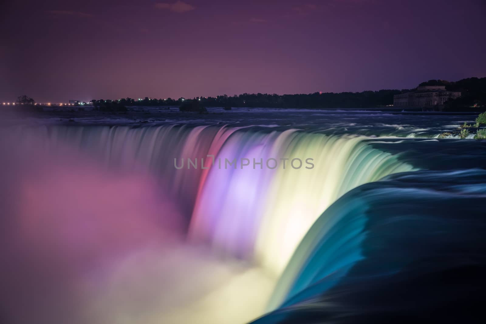 Niagara Falls at night illuminated by colored lights