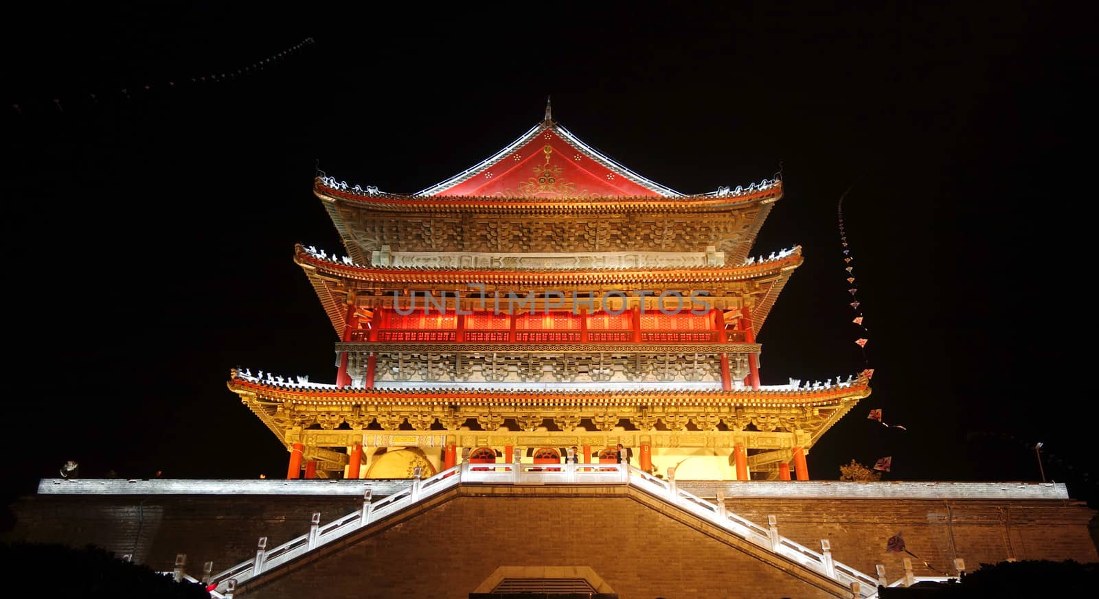 The illuminated ancient Drum Tower located inside the ancient city wall at night time, Xian, Shaanxi Province, China 