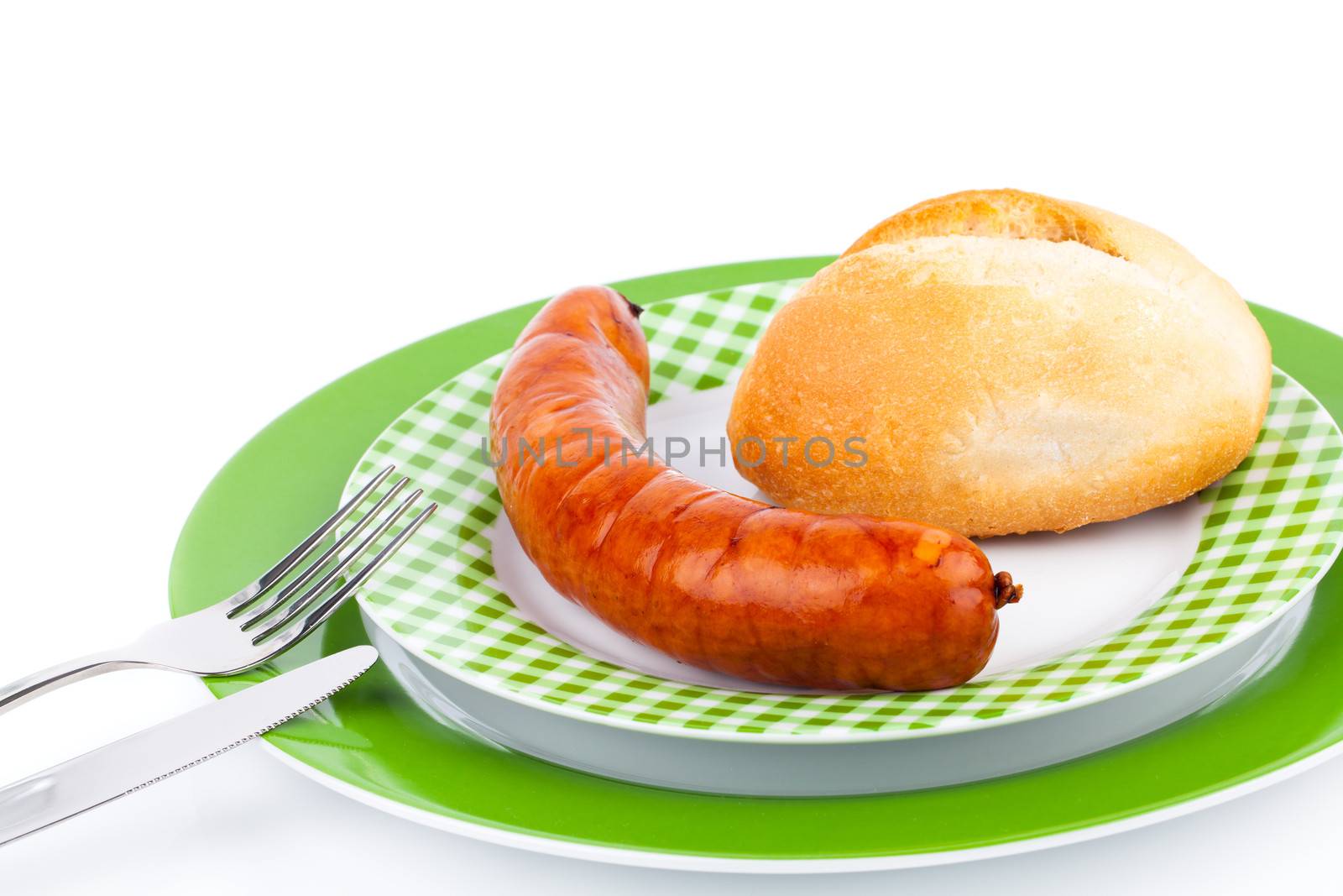 Stack of cooked sausages on a plate with bun