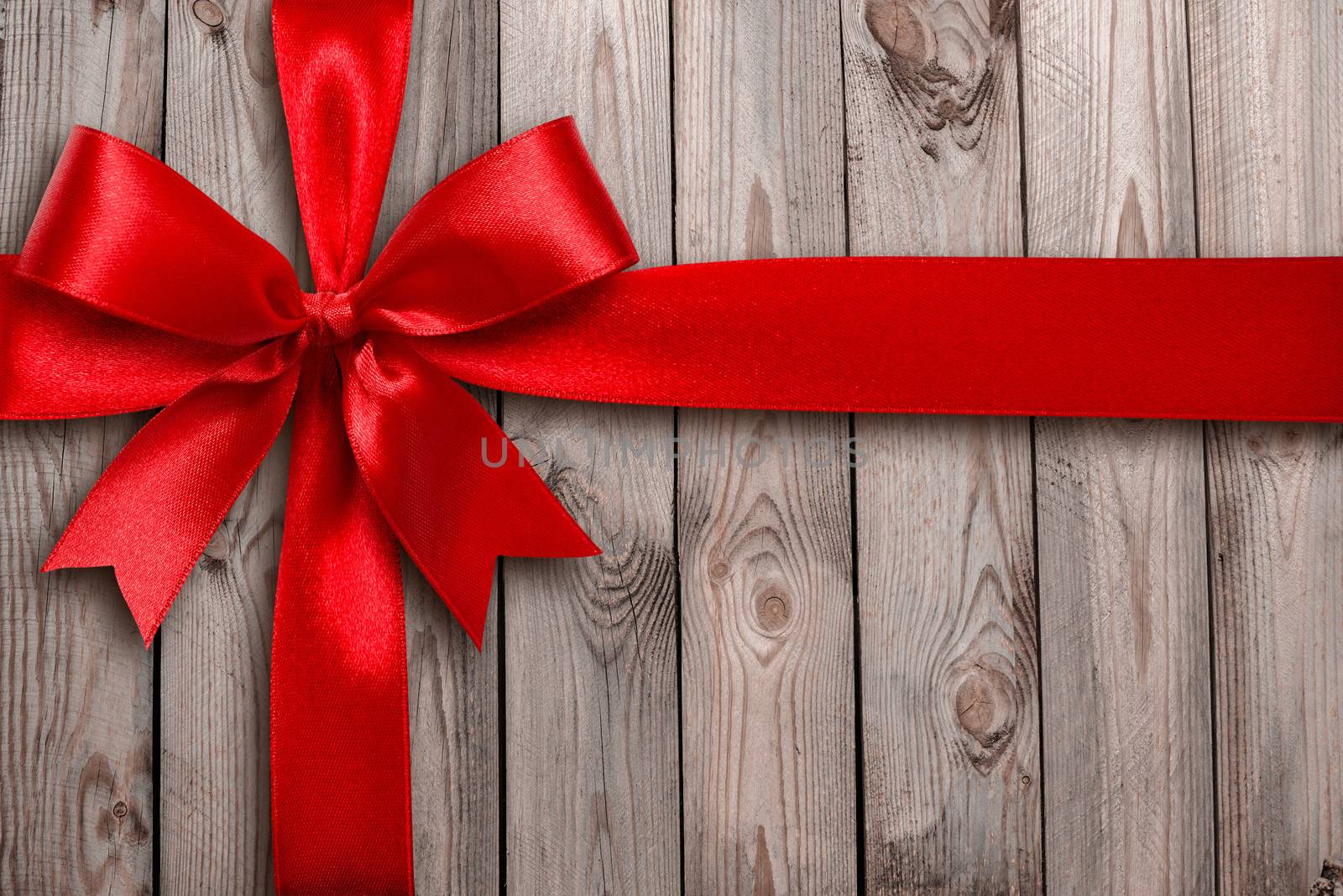 Red ribbon on a wooden background