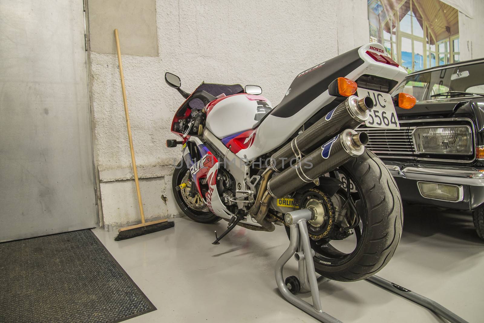 racing motorcycles in a garage by steirus