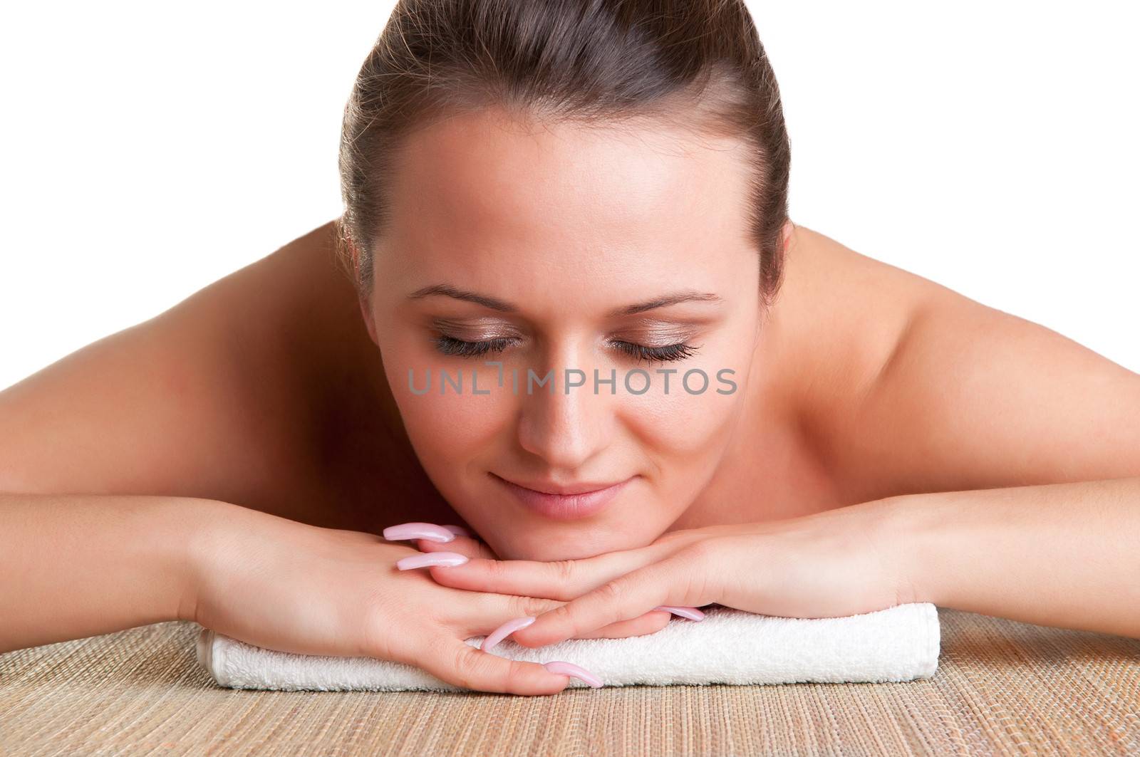 Young woman lying in a spa ready to get a massage, isolated in white