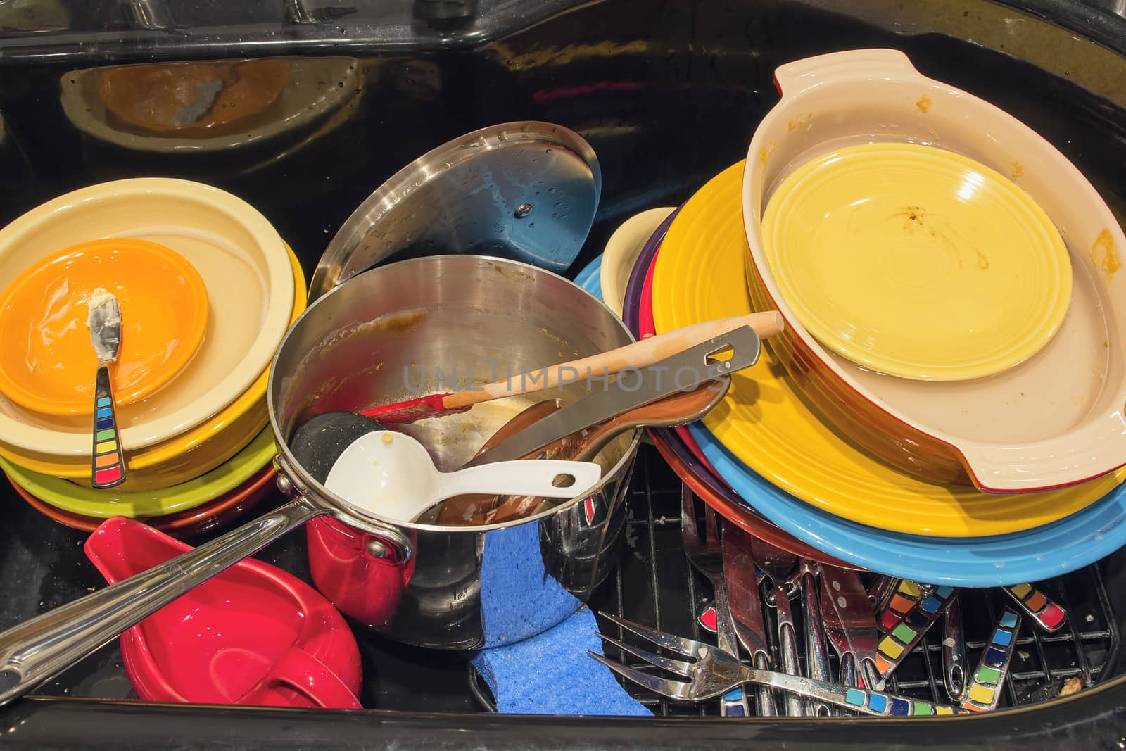 Kitchen Sink and Faucet Colorful Dirty Dishes Utensils Post Bowls Plates After a Holiday Meal