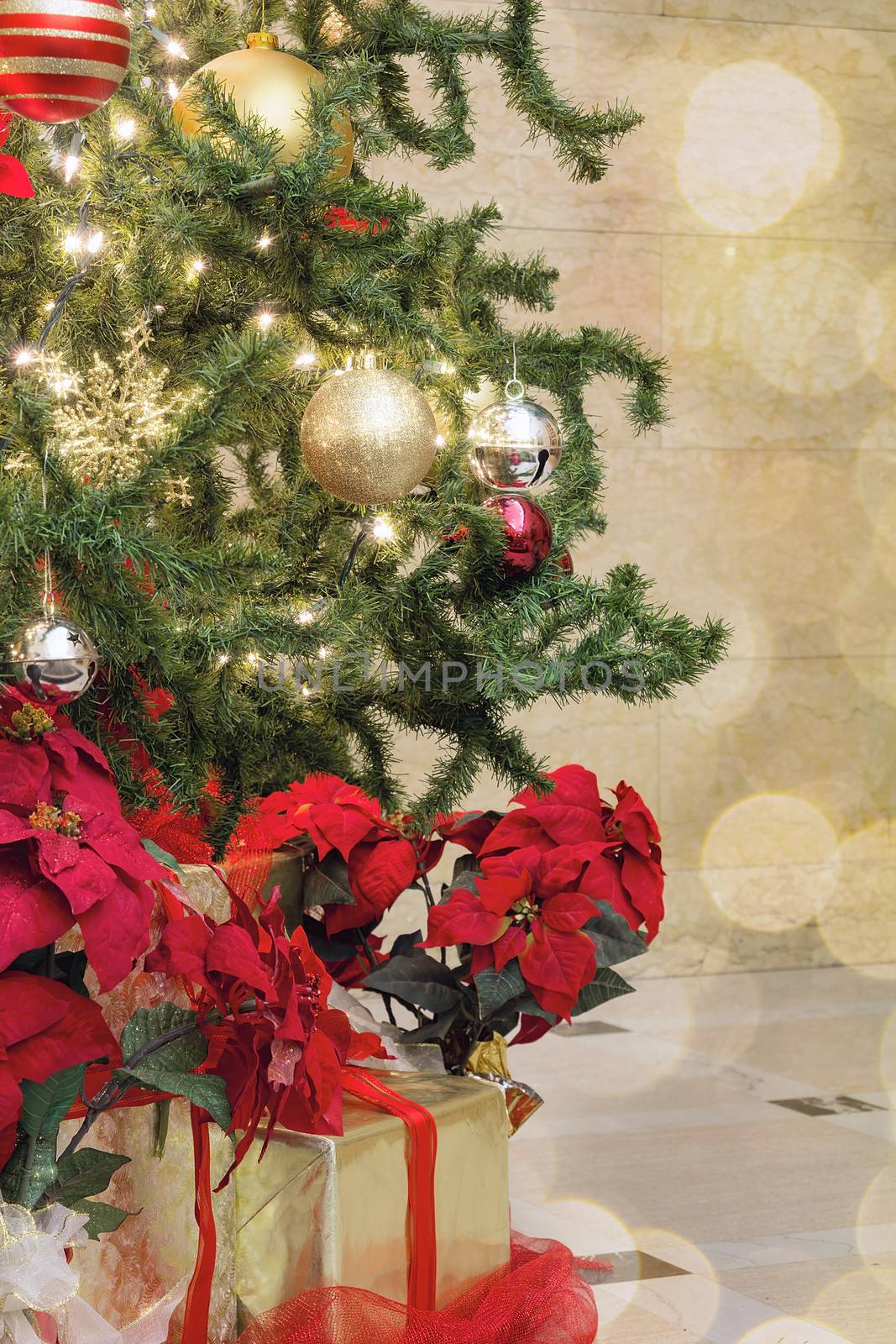 Christmas Tree Decoration with Bokeh Lights Sparkles Ornaments Ribbons Poinsettia and Presents Under the Tree