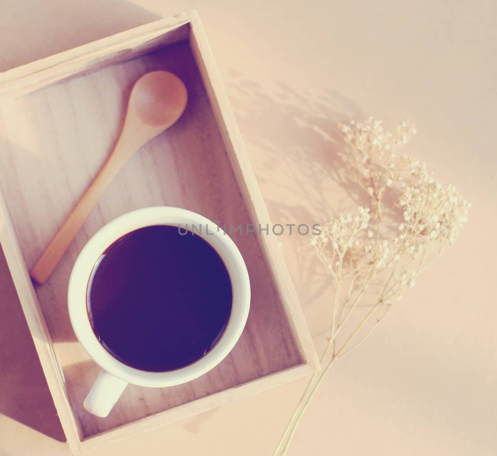 Black coffee and spoon on wooden tray with dried flower, retro f by nuchylee