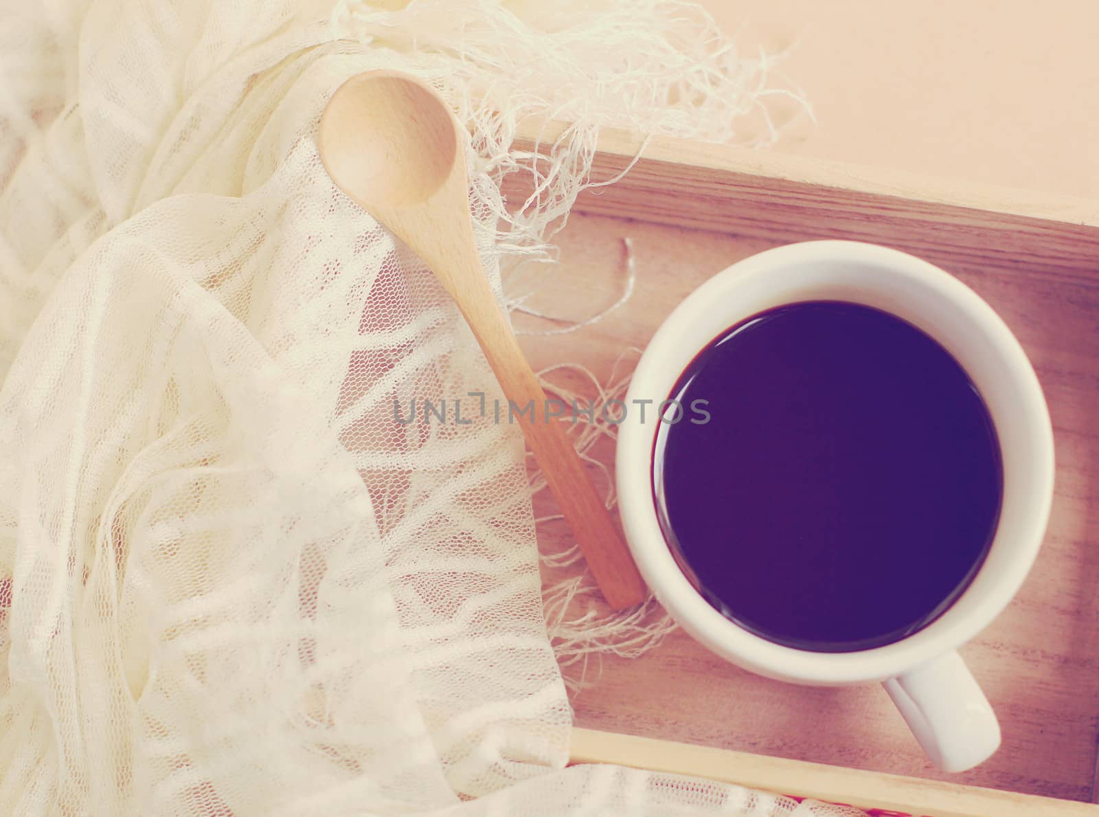 Silk scarf with black coffee and spoon on wooden tray, retro fil by nuchylee