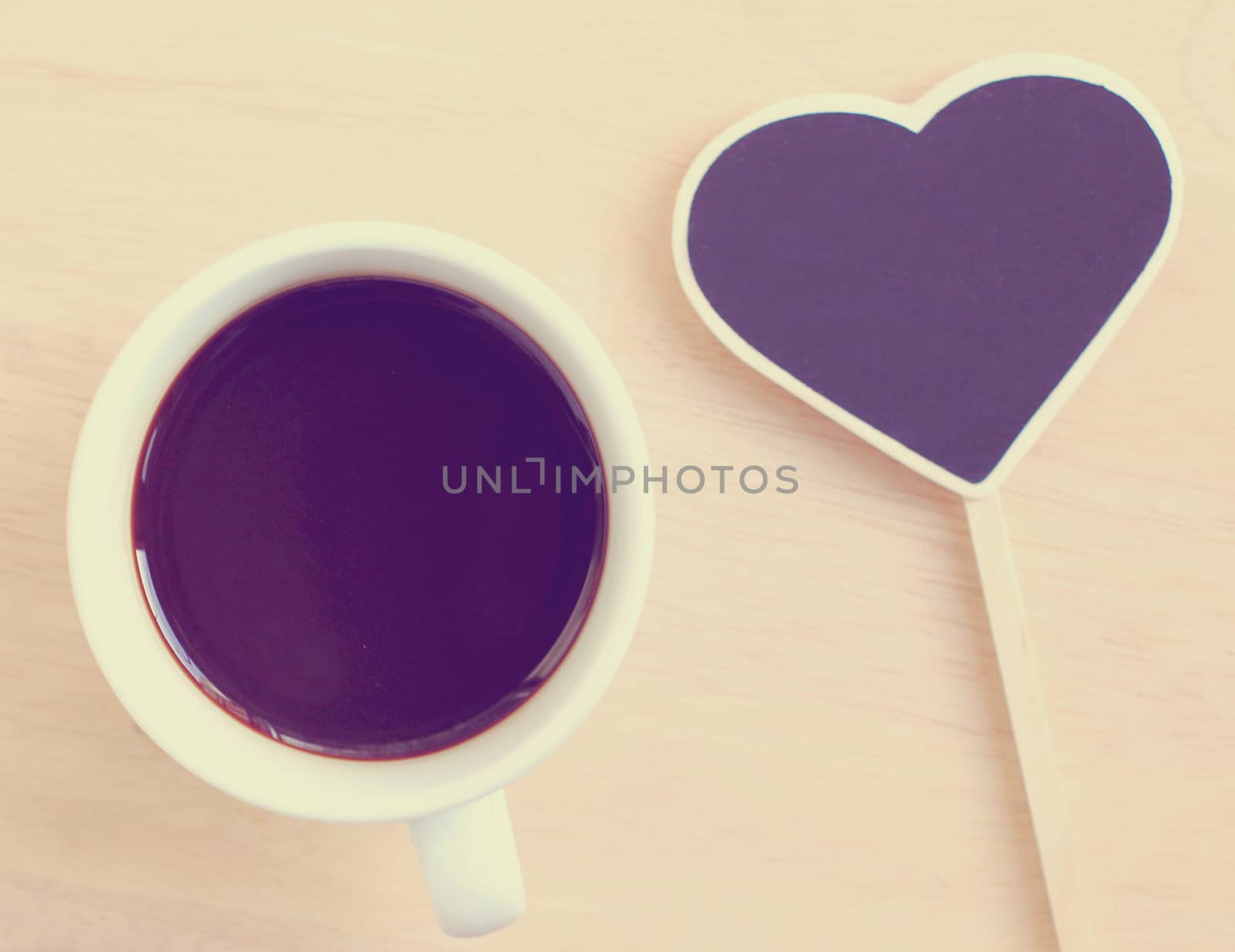 Black coffee and heart shape blackboard with retro filter effect