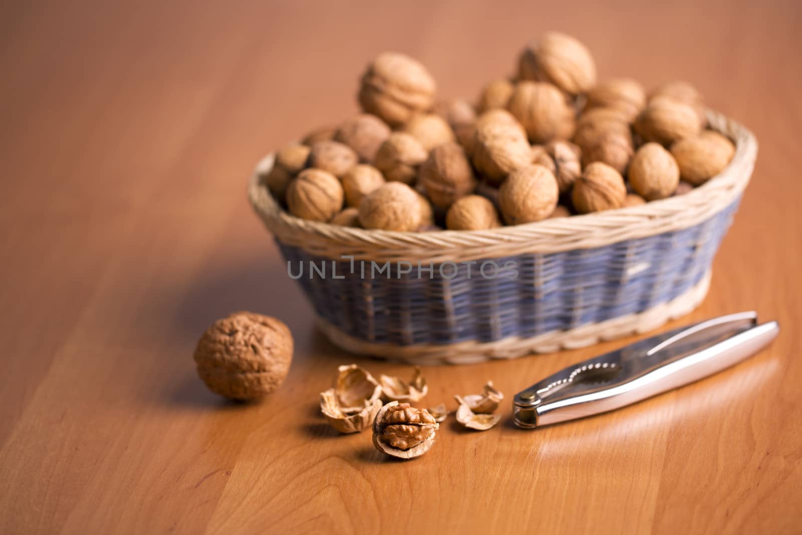 Nuts in a basket with the nutcracker, on a wooden background.