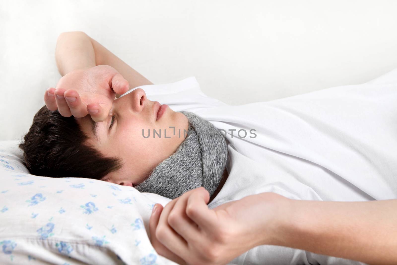 Diseased Young Man lying on the Bed and feels Headache