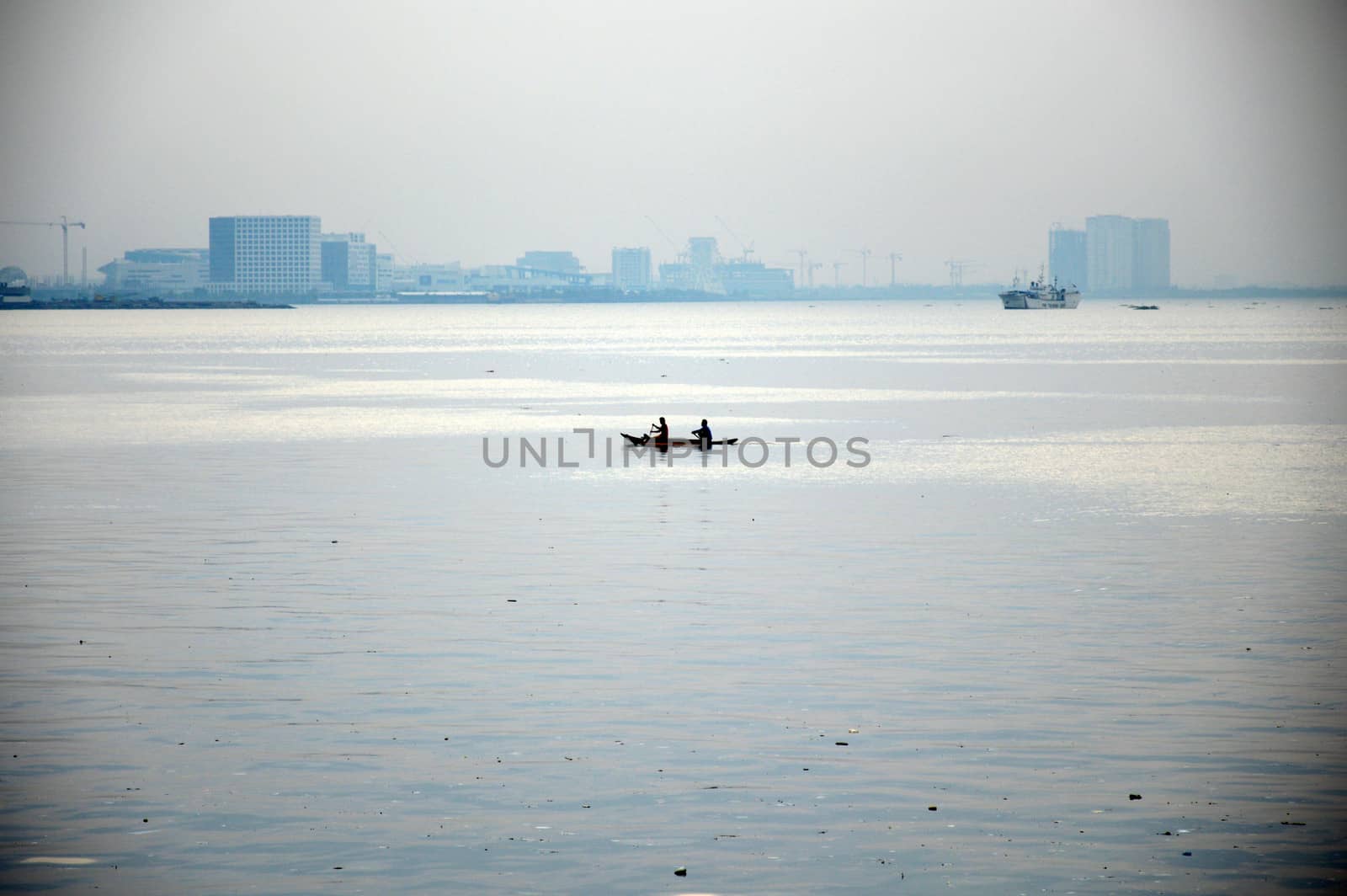 two men in a small boat in the middle of the ocean