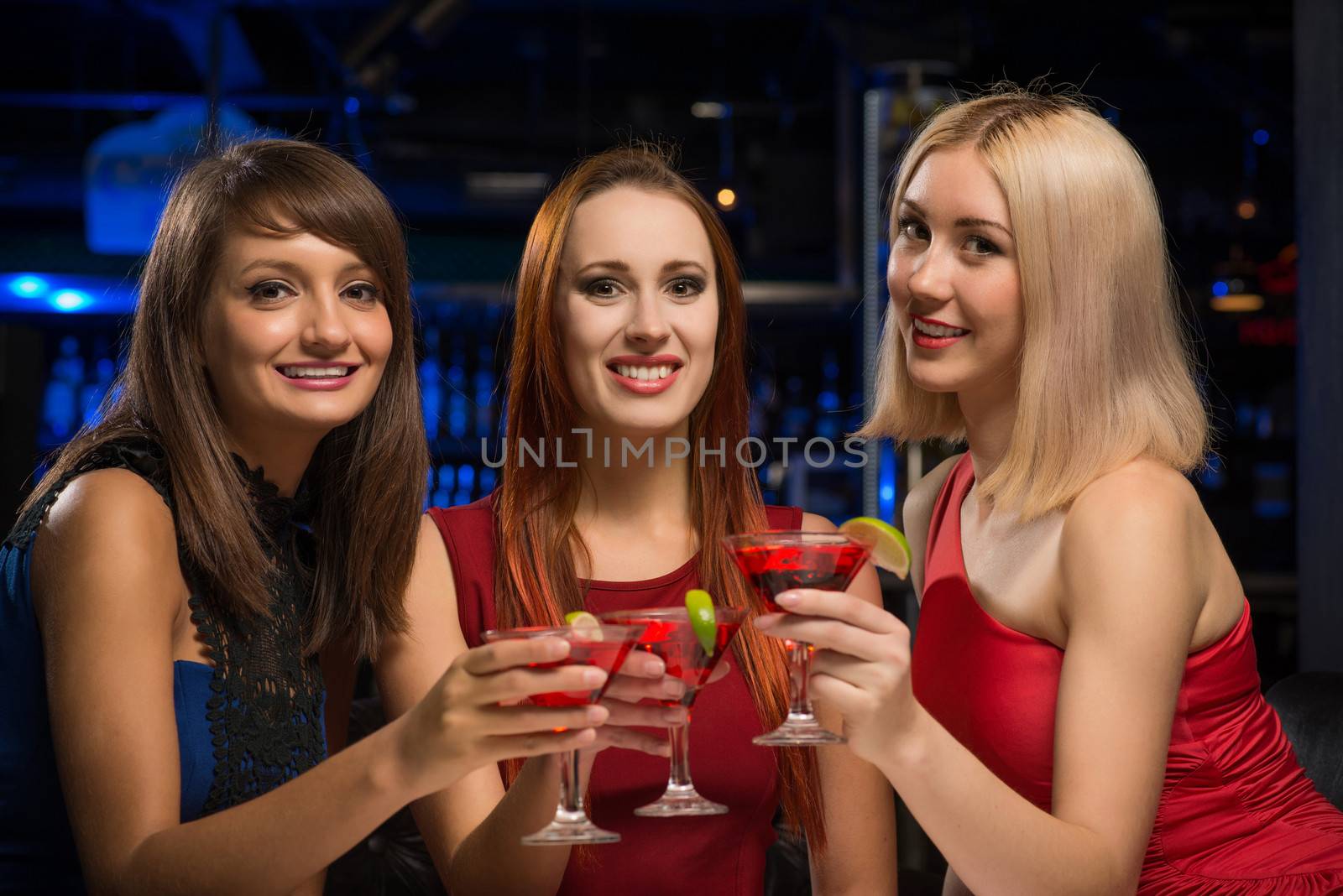 three girls raised their glasses in a nightclub, have fun with friends