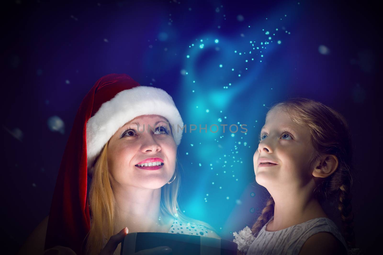 mother in Santa Claus cap and daughter opened a box with Christmas gift boxes of shining light and magic