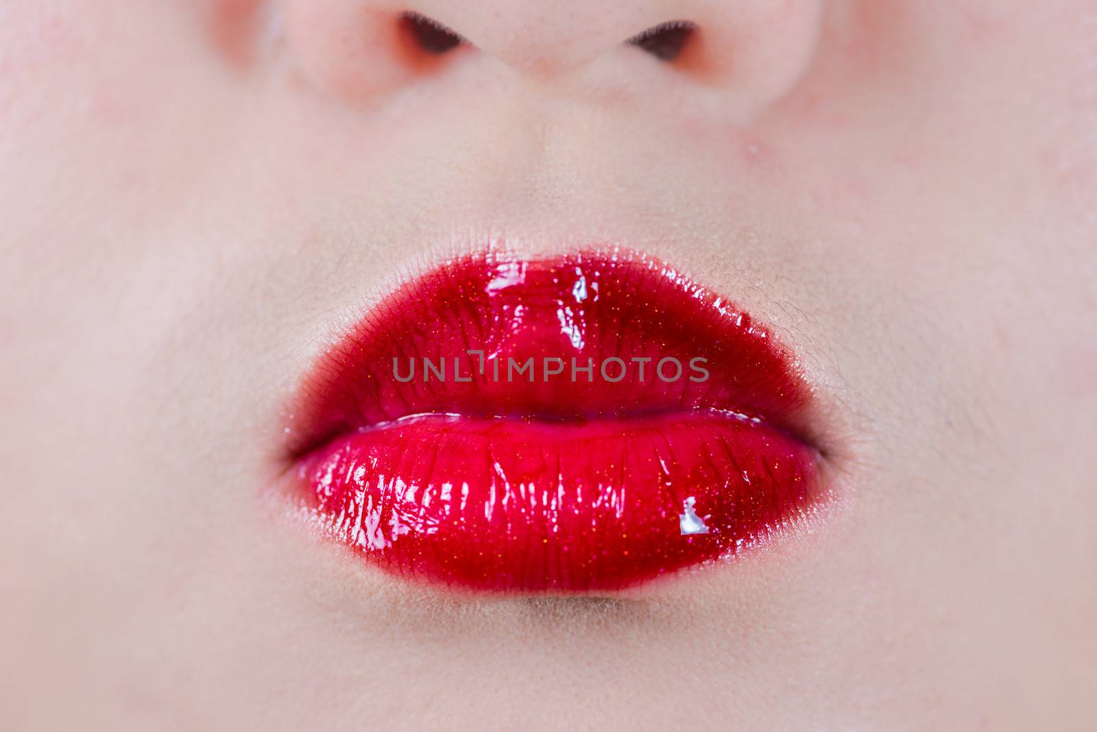 Closeup of woman's lips with makeup blowing a kiss