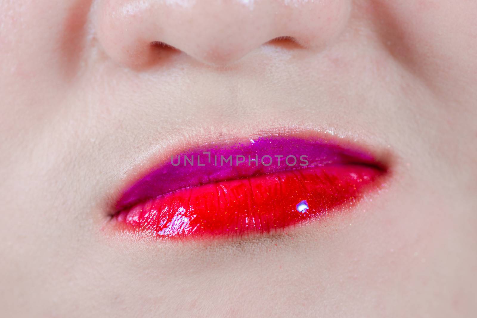 Woman lips with makeup and smirk by IVYPHOTOS