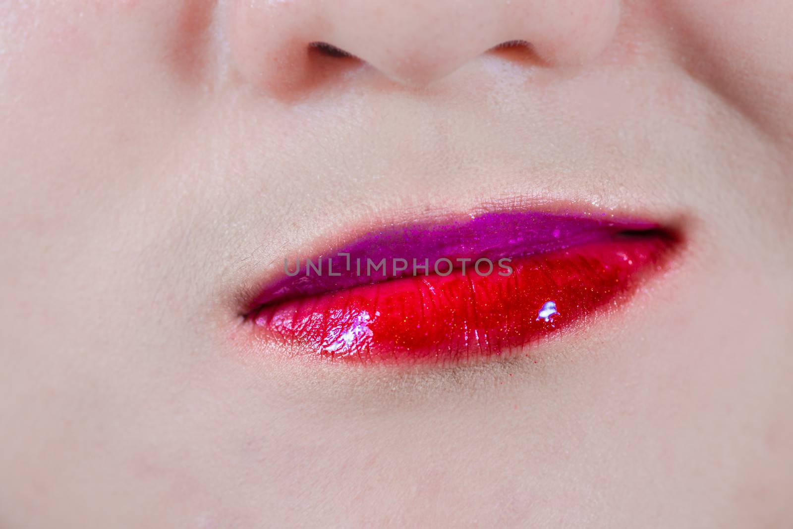 Woman lips with makeup and smirk by IVYPHOTOS