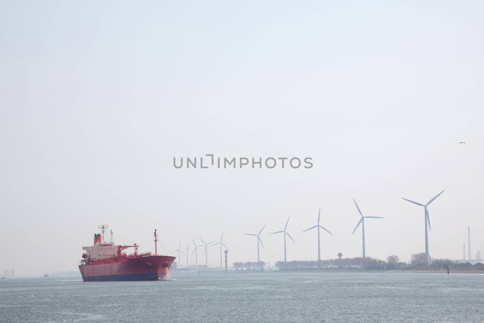 windmills and oil tanker in Nieuwe Waterweg near port of Rotterdam in The Netherlands