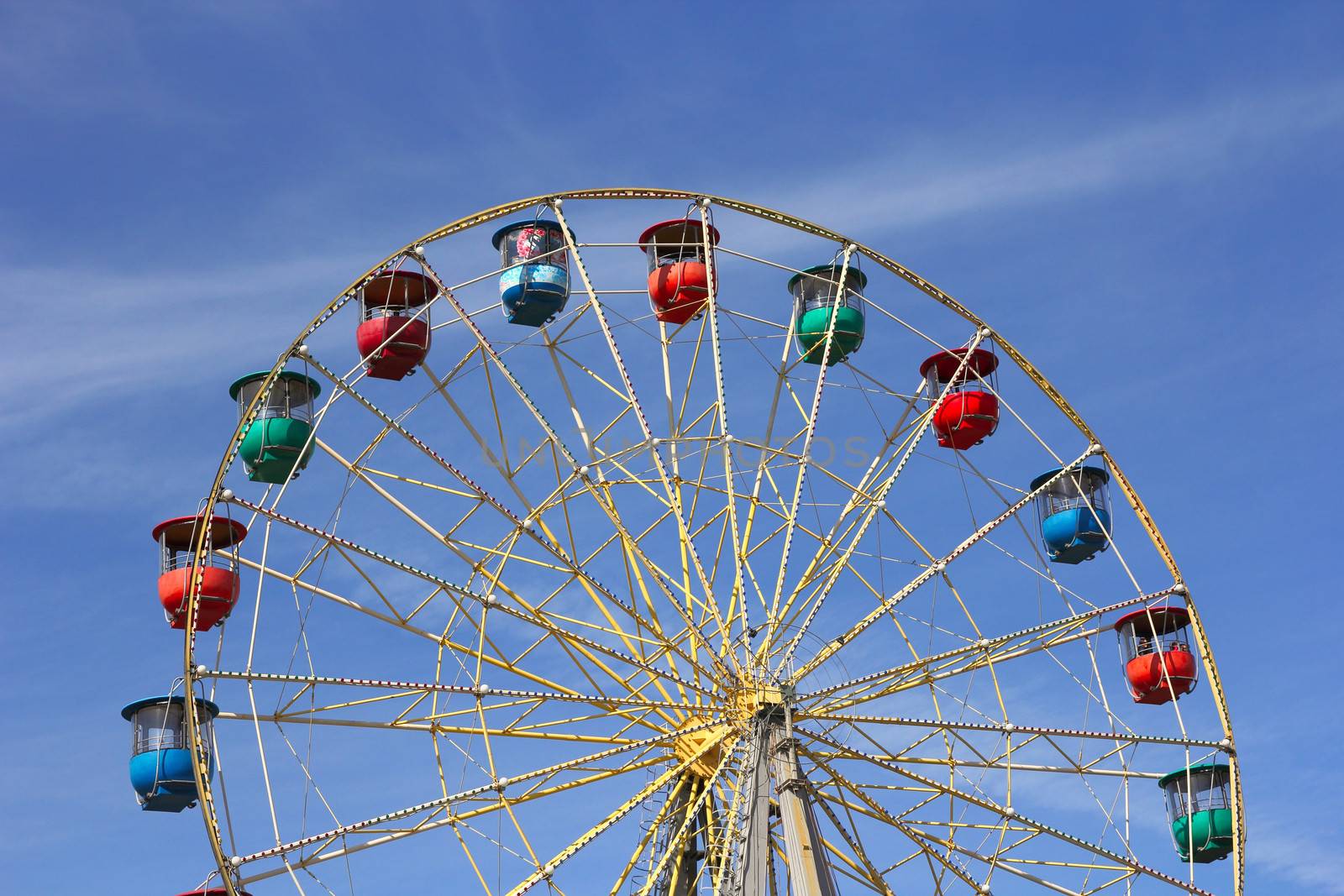 Atraktsion colorful ferris wheel against the blue sky by aarrows