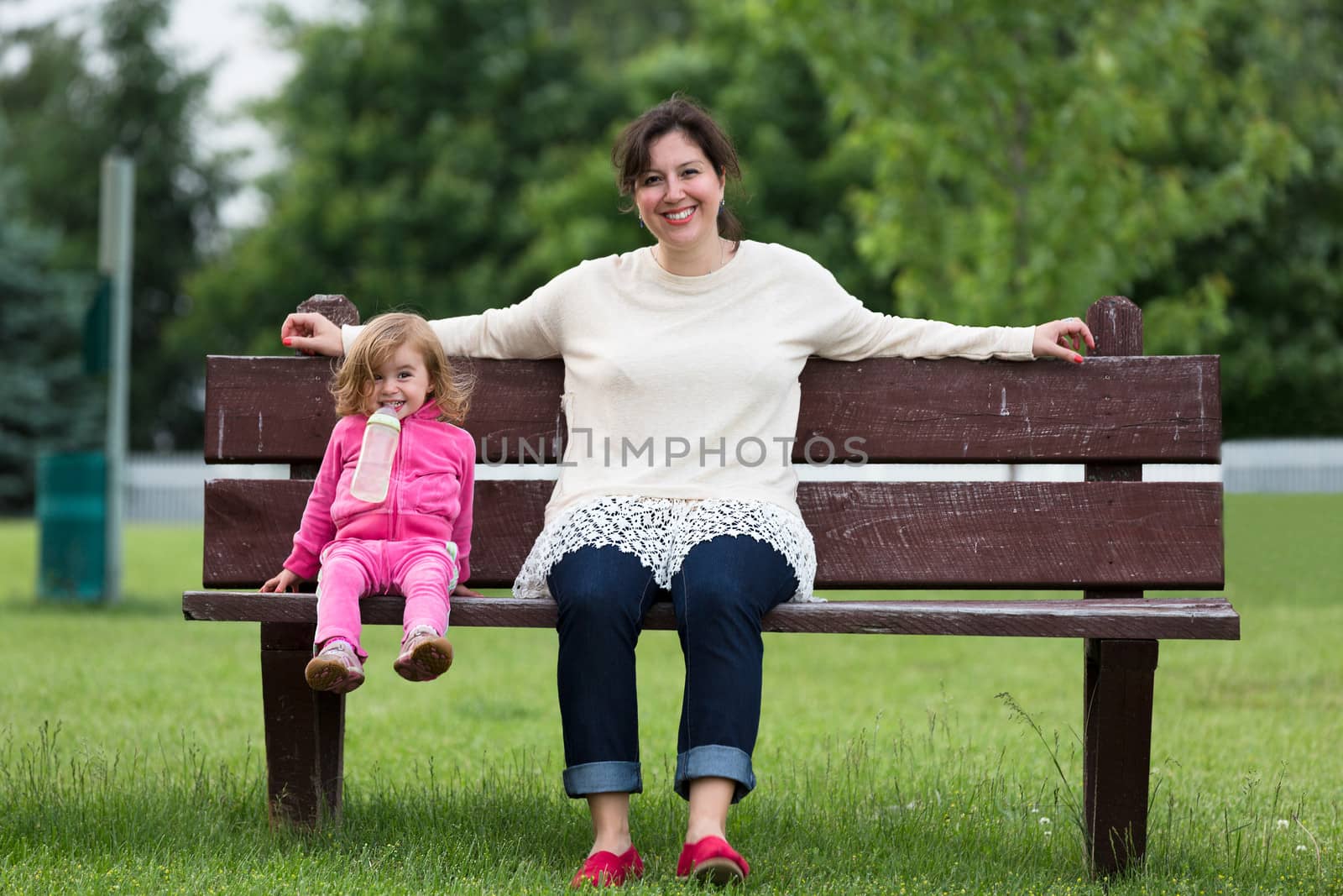 Mother and Her Daughter having Fun Outside on the Bench by coskun