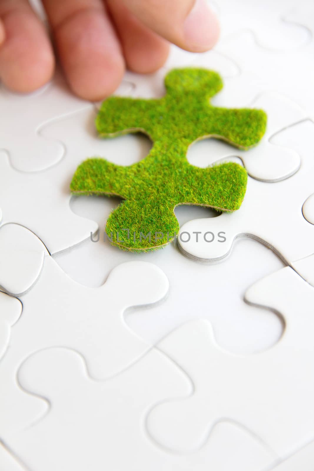 hand holding a green puzzle piece, green space concept by ponsulak