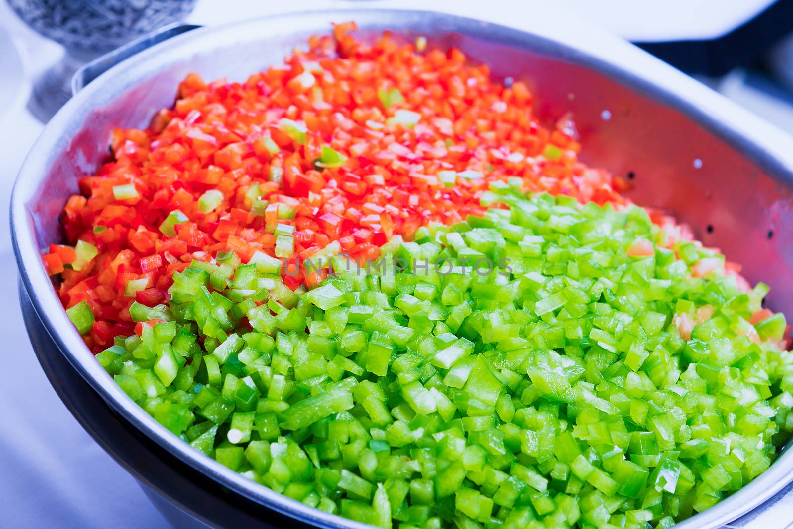 Green and red bell peppers cleaned and washed as cooking Ingredient in the restaurant in a big strainer basket