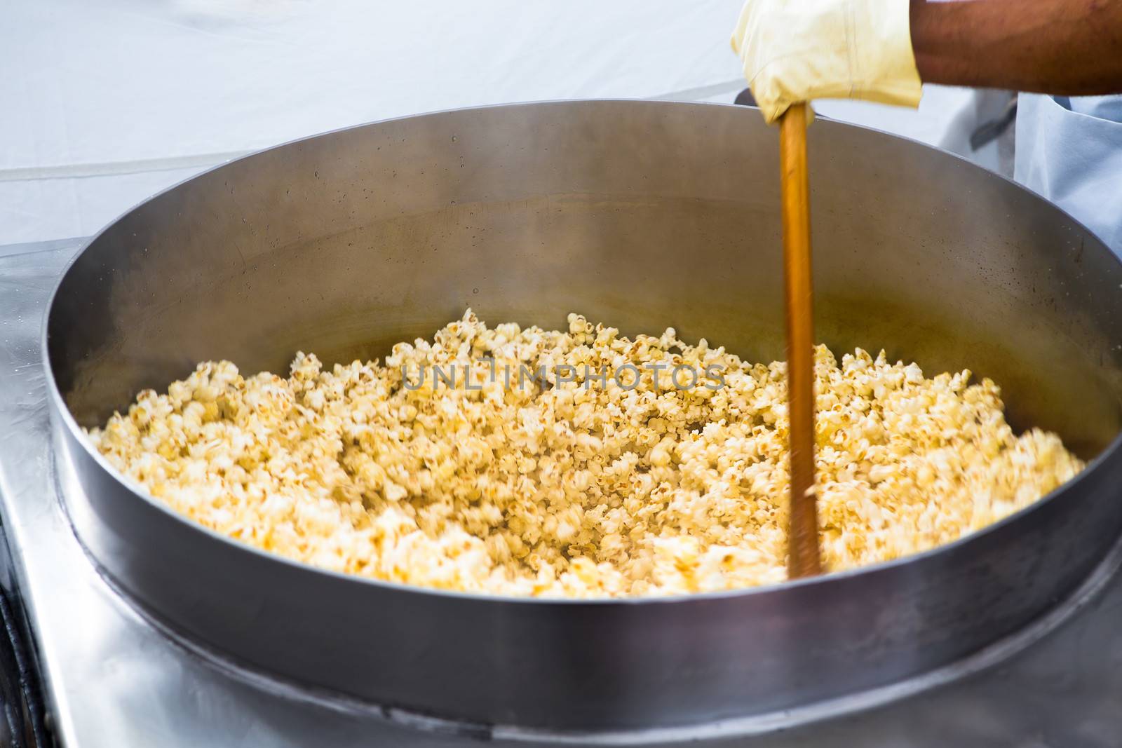 Twirling popcorn's in the huge pan going crazy and popping