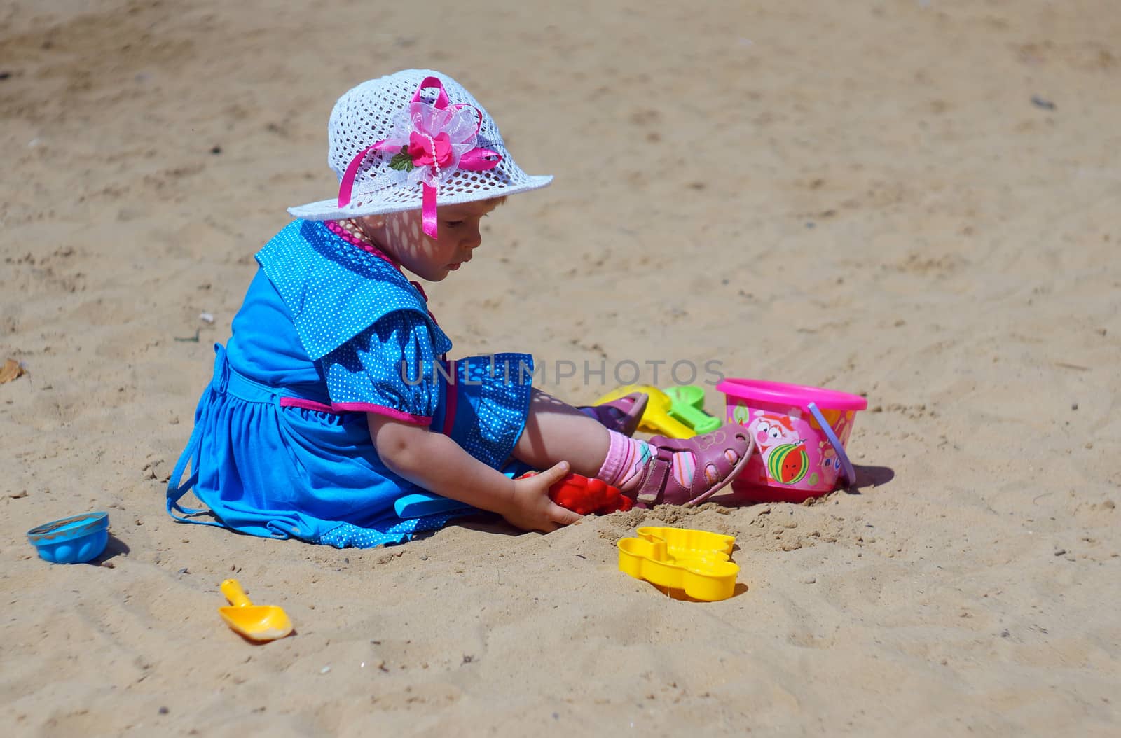 Two-year-old girl playing in a sandbox