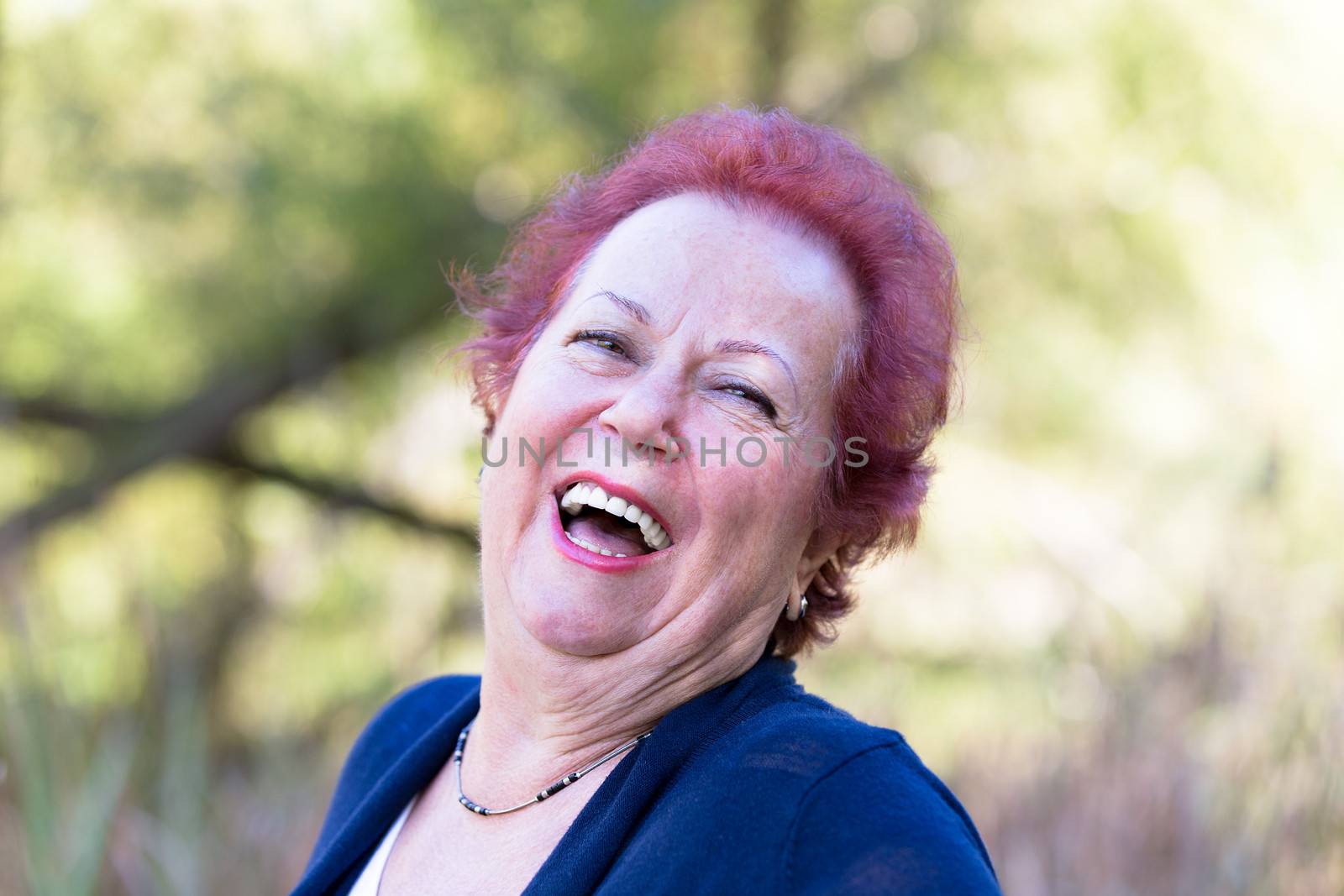 Red hair enthusiastic senior woman giving a genuine laugh