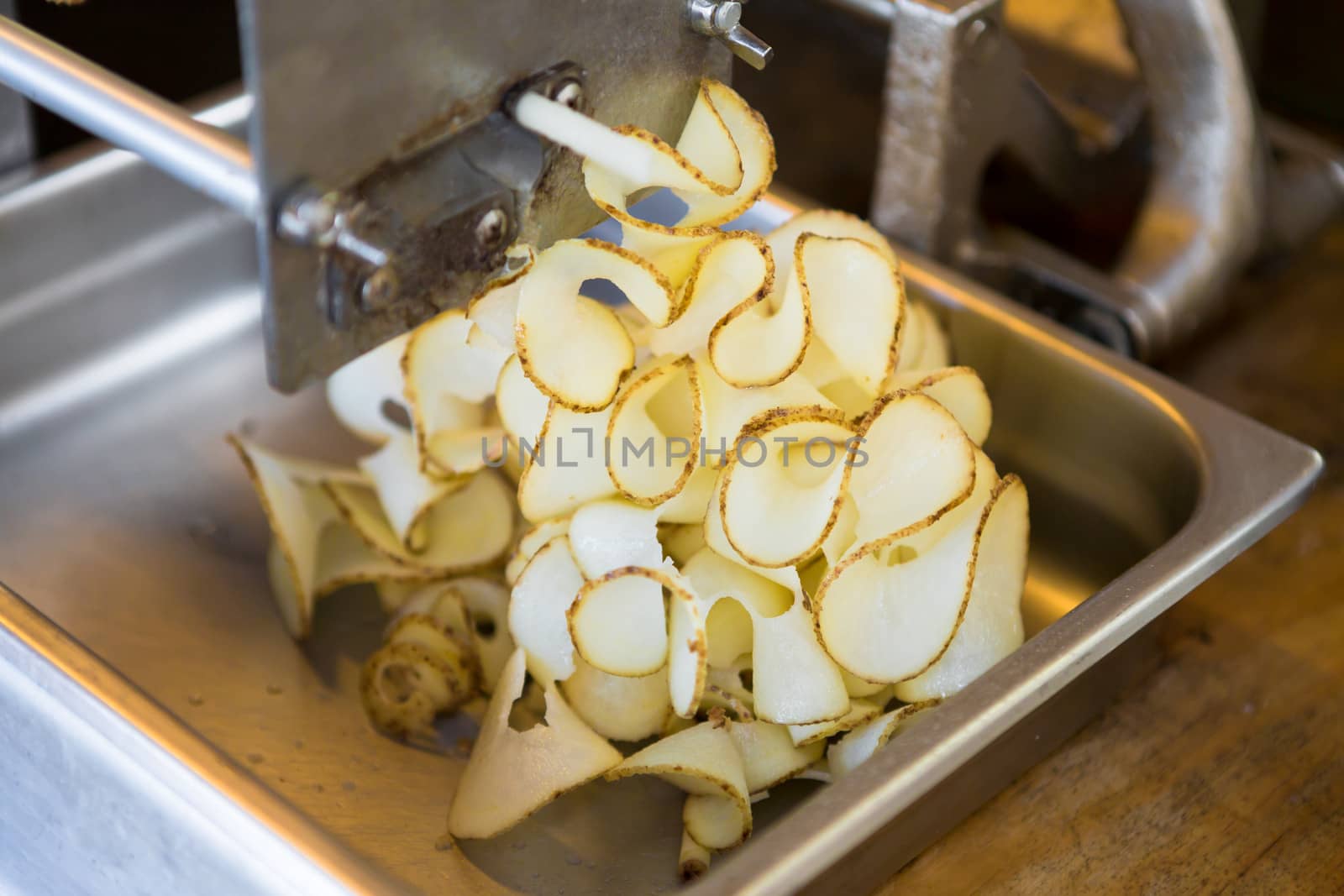 Prepearing curly, ribbon potato fries in the kitchen,