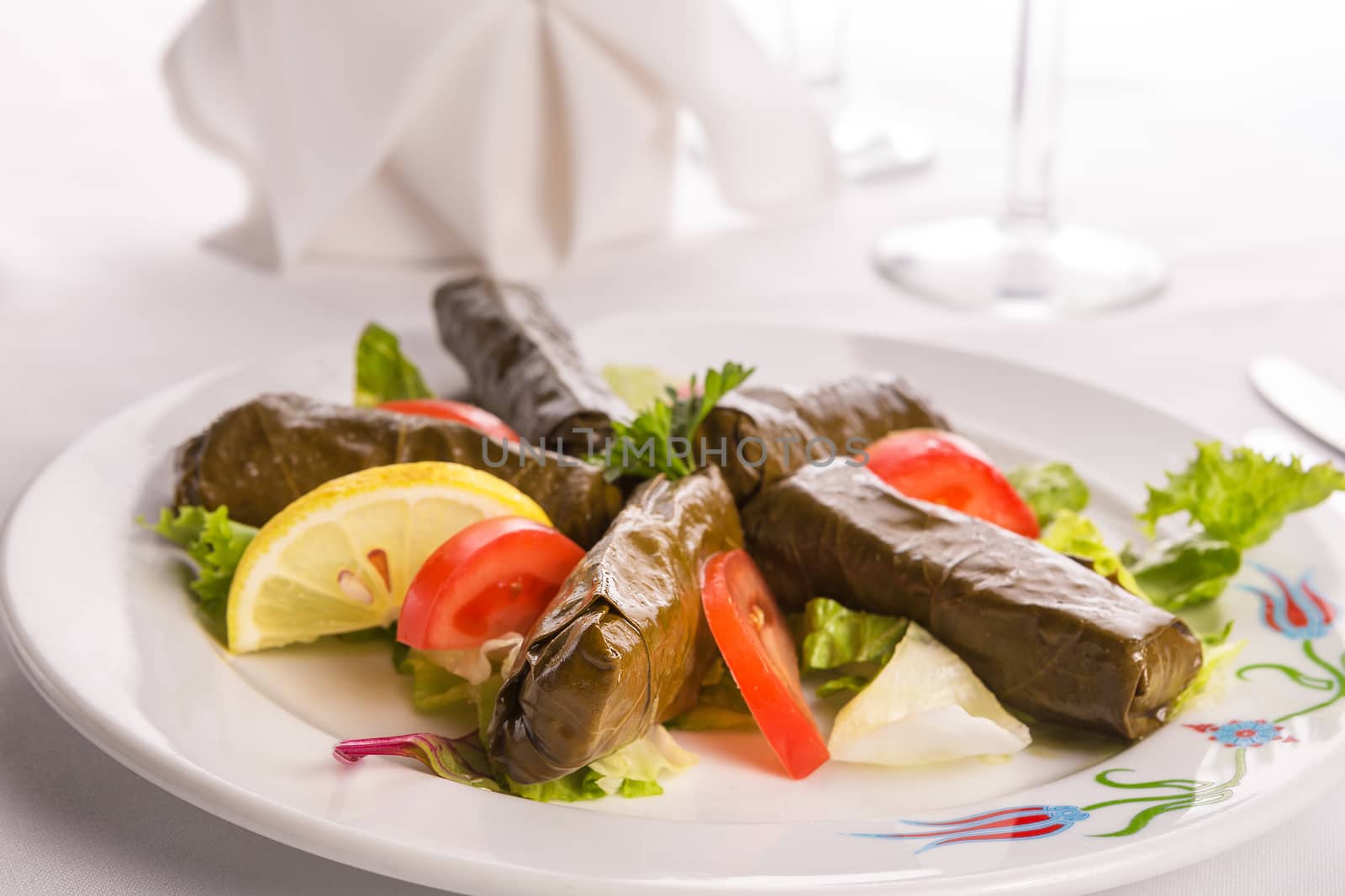 Turkish style dolmas arranged with slice of tomatoes, lemon and Lettuce