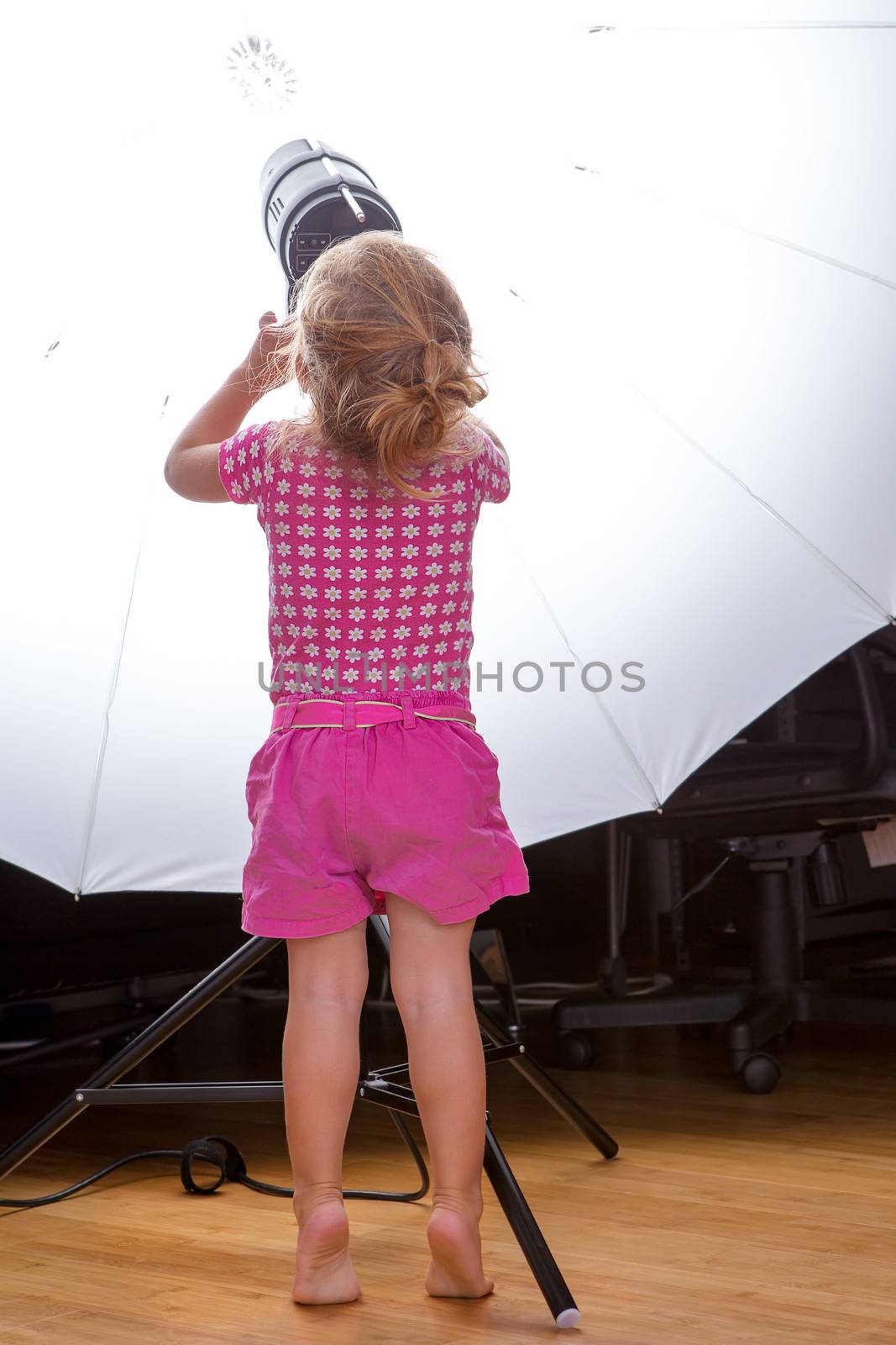 Little mischievous toddler girl at the Studio adjusting the Strobes settings on her toes