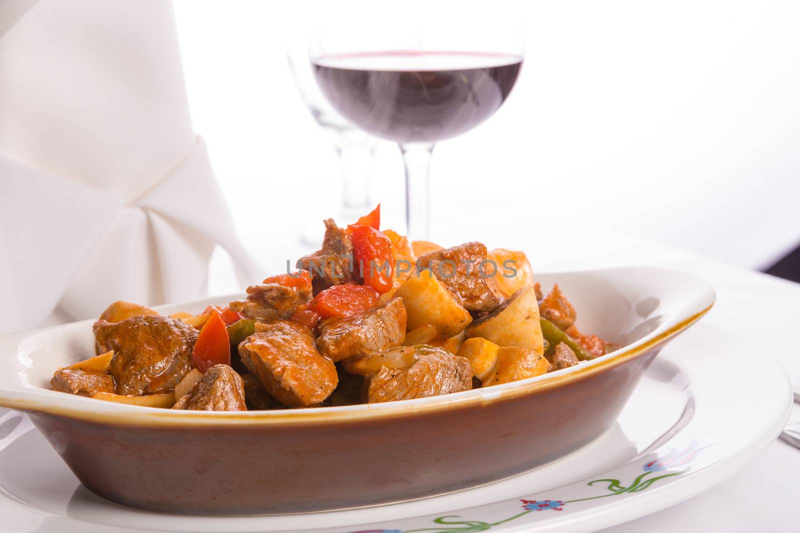 Beef Saute  with tomatoes, mushrooms and onions served in oval baking dish along with red wine