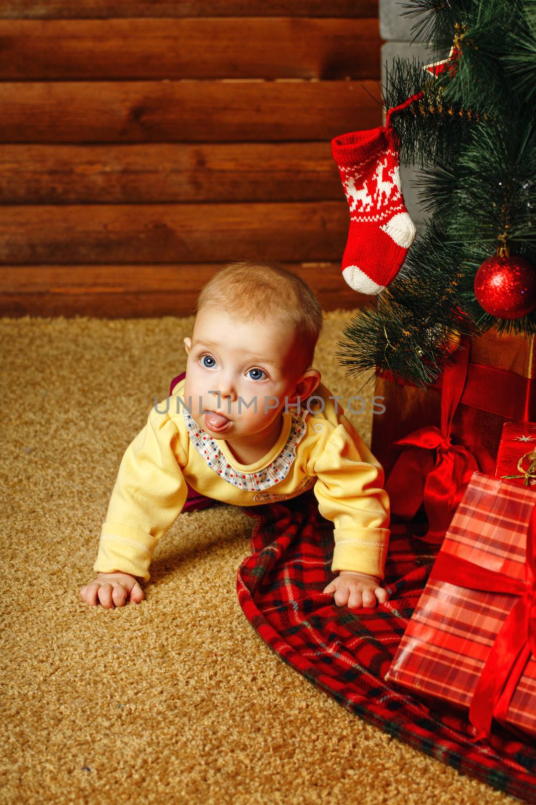 Redhead babe with blue eyes lies near the Christmas tree and gifts