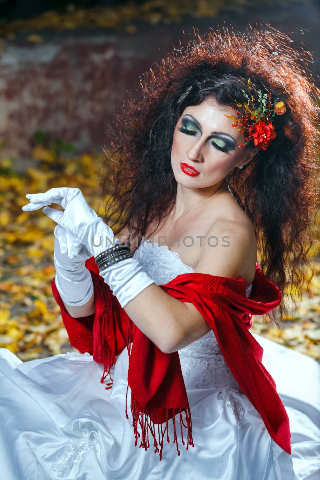 Attractive bride in a wedding dress with bright makeup, red shawl