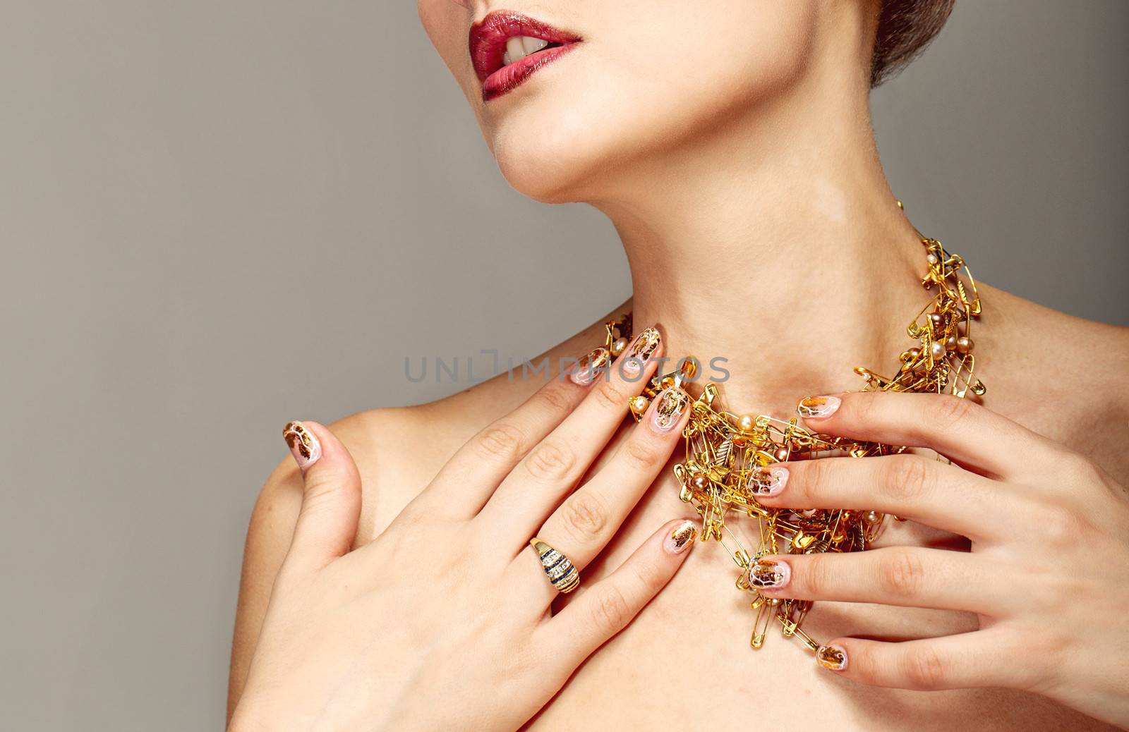 Trendy nail design and beautiful necklace of golden pins safe