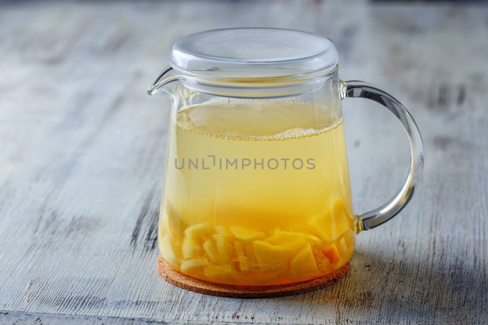 Glass tea kettle on the wooden table closeup shot