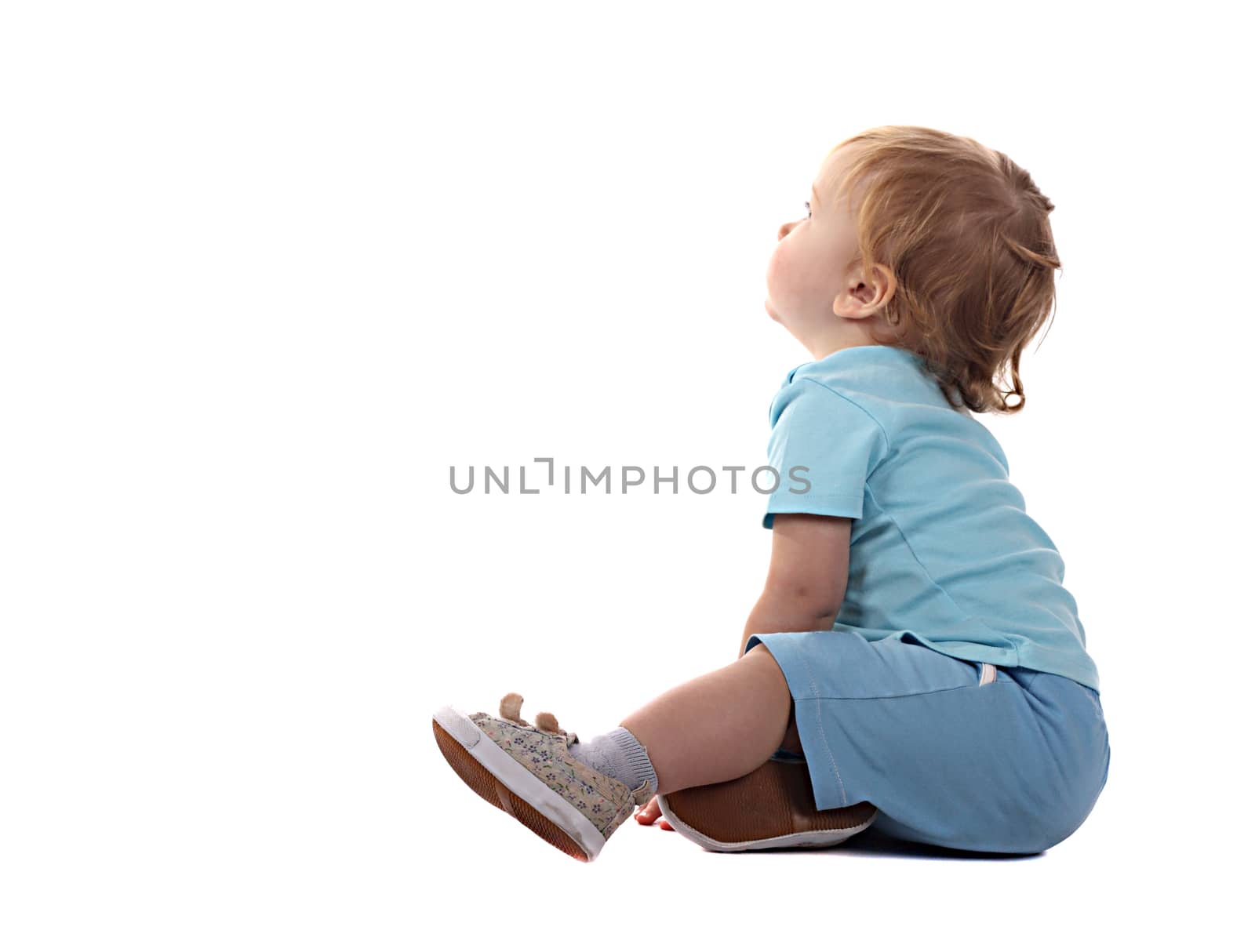 Little boy stting and looking isolated on the white