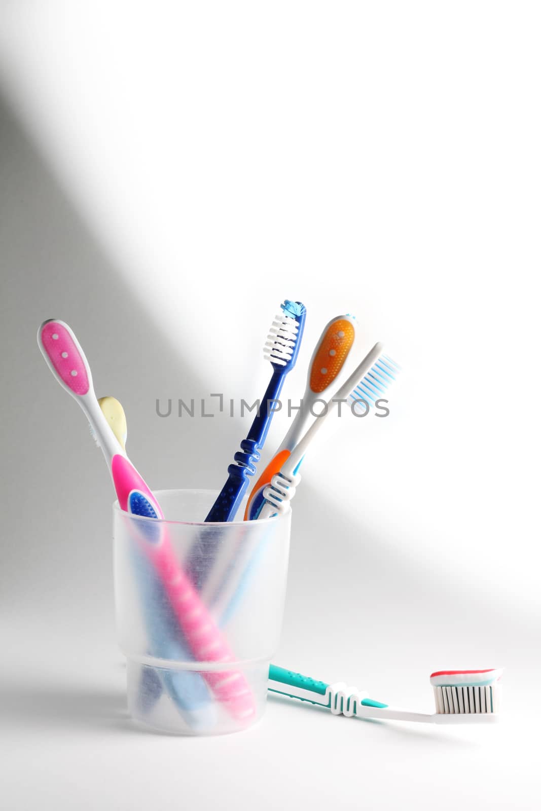 Some toothbrushes in a plastic glass