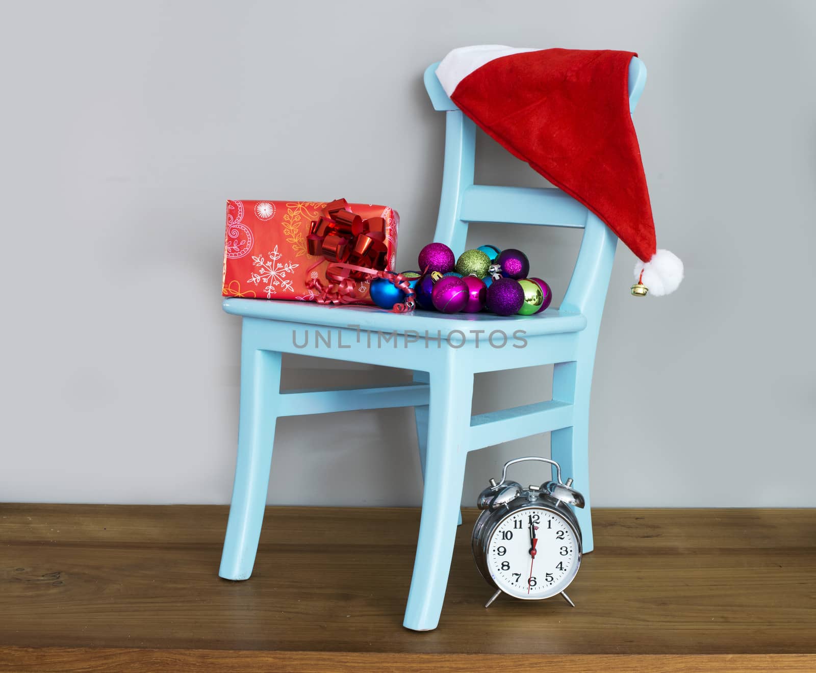 santa claus hat on chair with presents and balls for christmas
